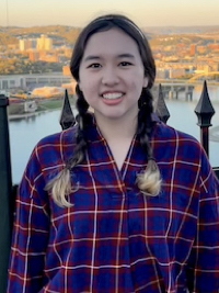 Emily in a plaid shirt with the Duquesne Incline in the background.