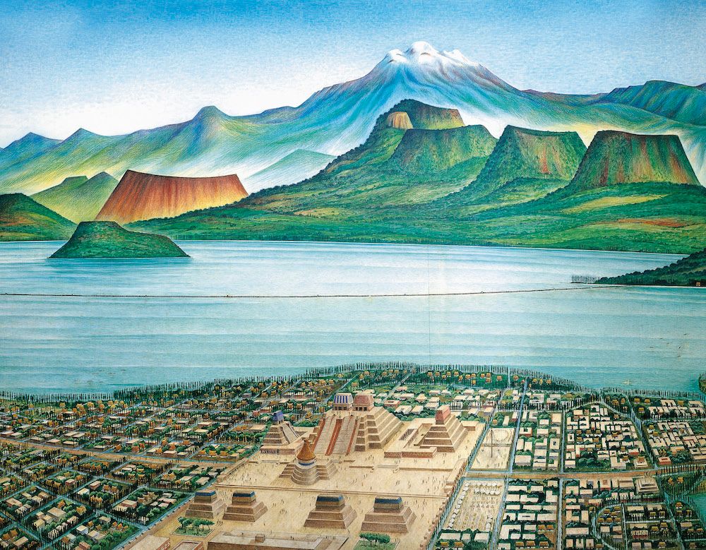 Overhead view of a group of temples surrounded by smaller city dwellings on a waterfront. Across the water is a mountain rage.