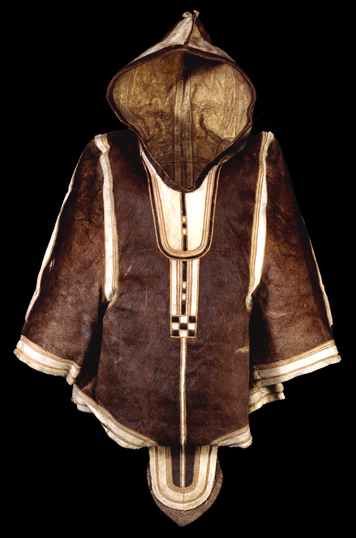 Girl's caribou skin parka, Inuit, early 19th century C.E., 76 cm high, from West Greenland © Trustees of the British Museum. This parka has contrasting mosaic-work made of the white belly skin of a young caribou. The curved flaps, front and rear, are characteristic of Arctic women's clothing. The edge of the hood would have been finished with a ruff or fringe of fur from animals such as wolf or wolverine. Their glossy hairs allow the accumulated ice, from breath and snow fall, to be shaken away.The parka may have been collected in the early nineteenth century during the search for the Northwest Passage. It is one of the first woman's parkas to be collected in Greenland, and is similar in design to those, discovered with mummies at Qilatiksoq in 1972-8, dating to about 1475.