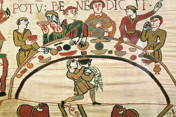 Norman’s first meal in England, at the center is Bishop Odo, who gazes out as he offers a blessing over the cup in his hand (detail), Bayeux Tapestry, c. 1070, embroidered wool on linen, 20 inches high (Bayeux Museum)