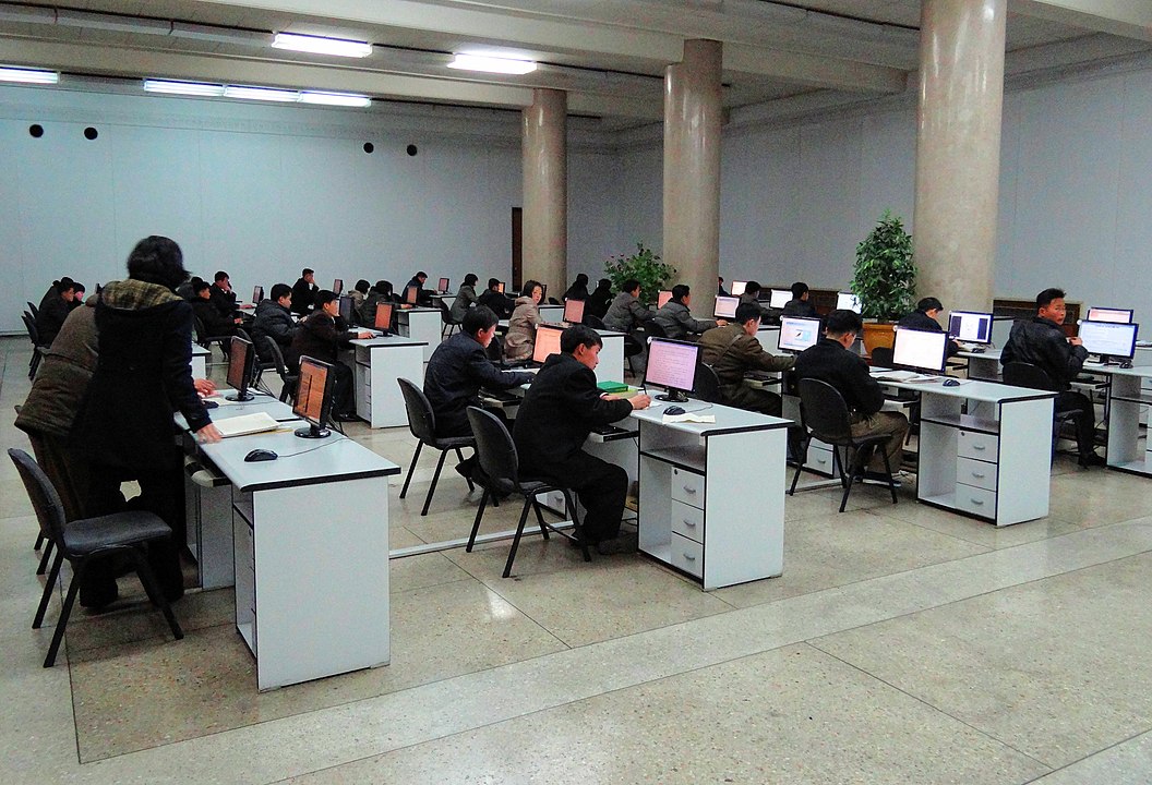 Hình ảnh một căn phòng với nhiều người Triều Tiên ngồi trước những chiếc máy tính để bàn