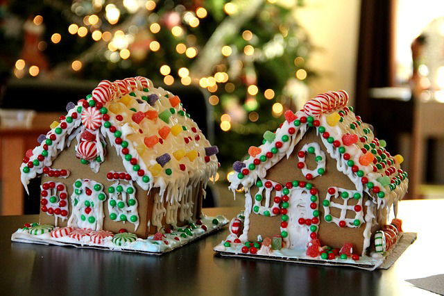 gingerbread houses! Detailed description of surroundings: blurred decorated christmas tree, part of a window 